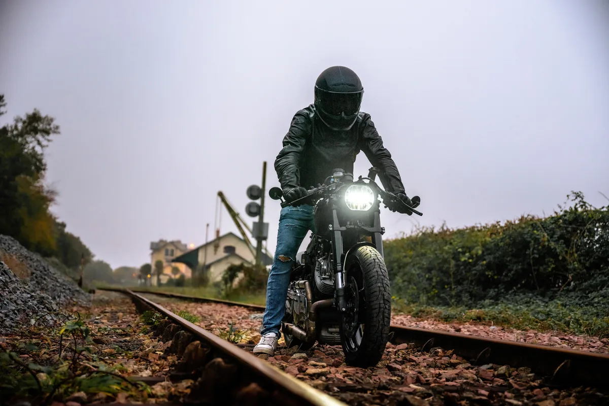 Un motard en approche sur sa moto, sur une ancienne voie ferrée.