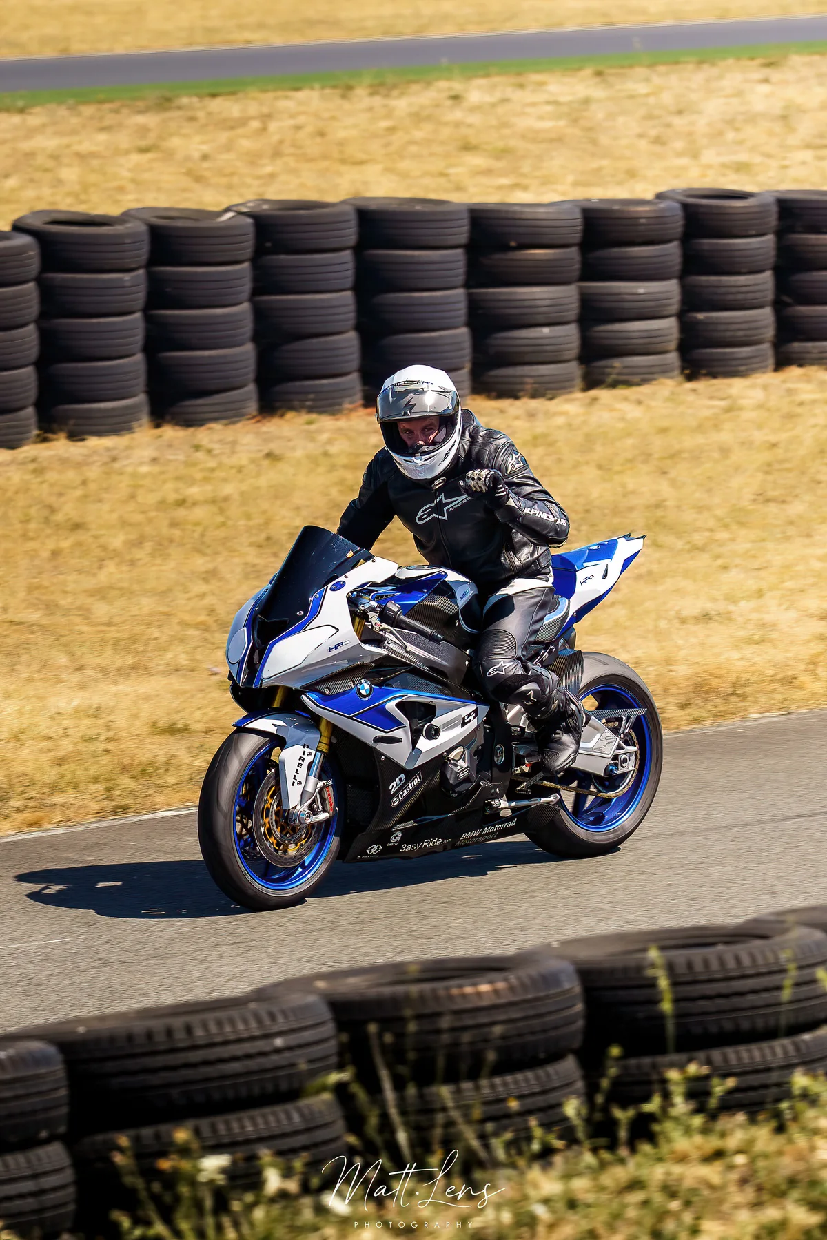 Un pilote en combinaison bleue prend un virage sur le circuit.