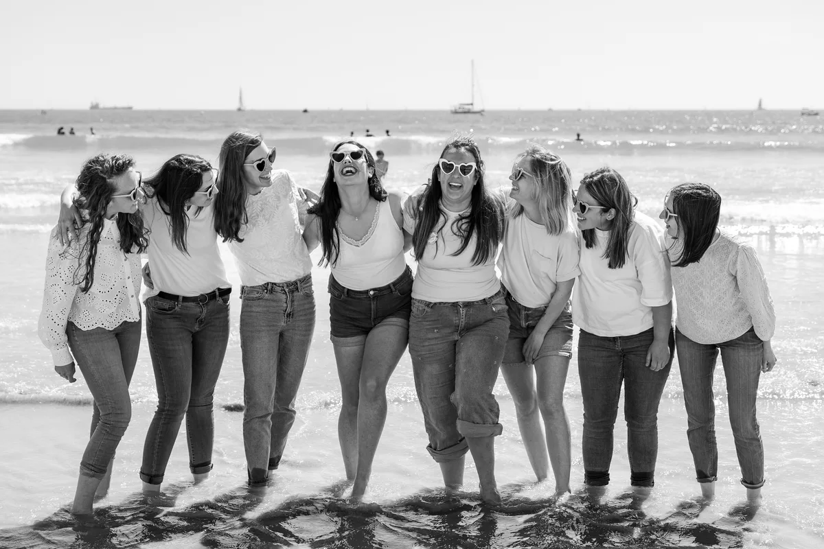 Les amies posent de dos sur la plage, en noir et blanc.