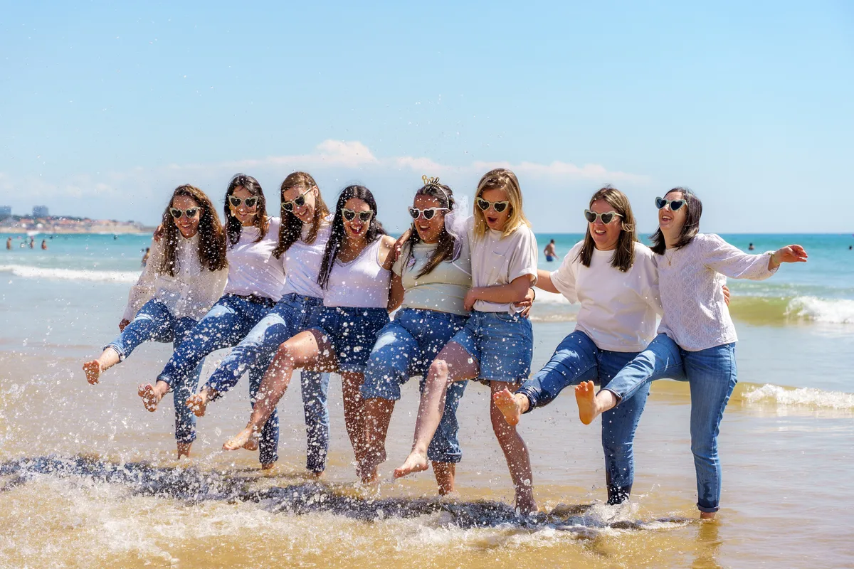 Les amies sautent ensemble au bord de la mer pendant un EVJF.