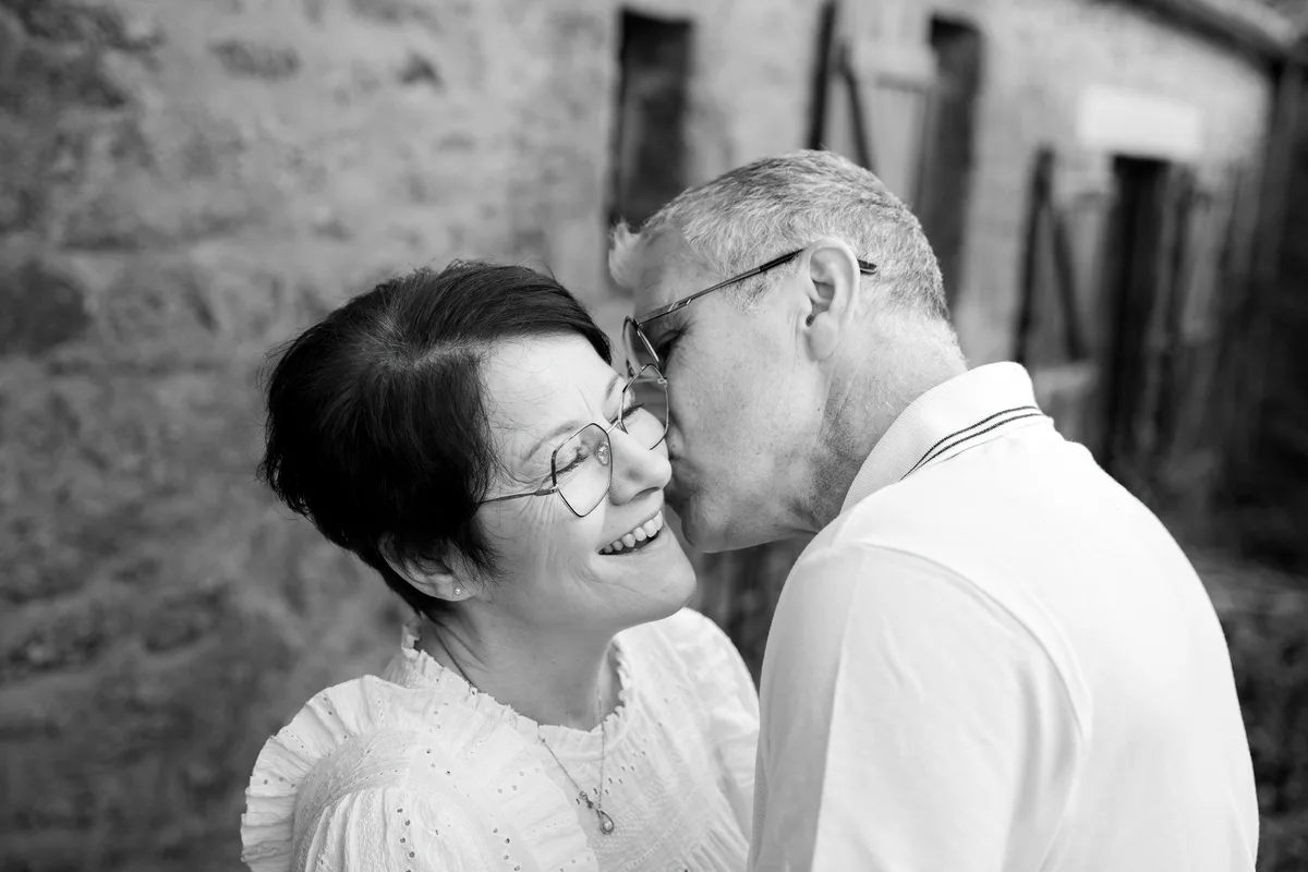 Un couple s’embrasse, portrait intimiste en noir et blanc.