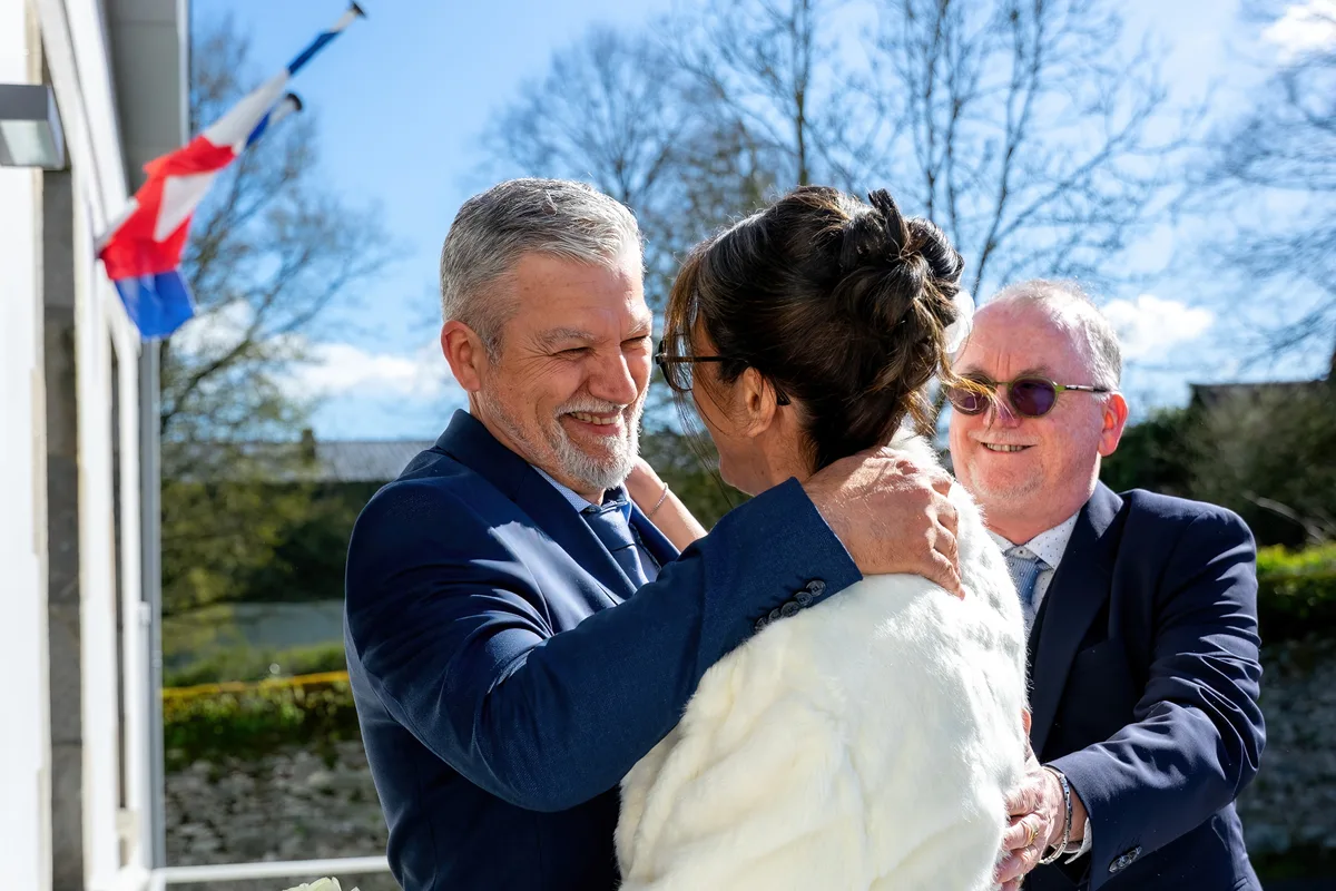 Le marié enlace la mariée pendant les retrouvailles avec leurs proches.