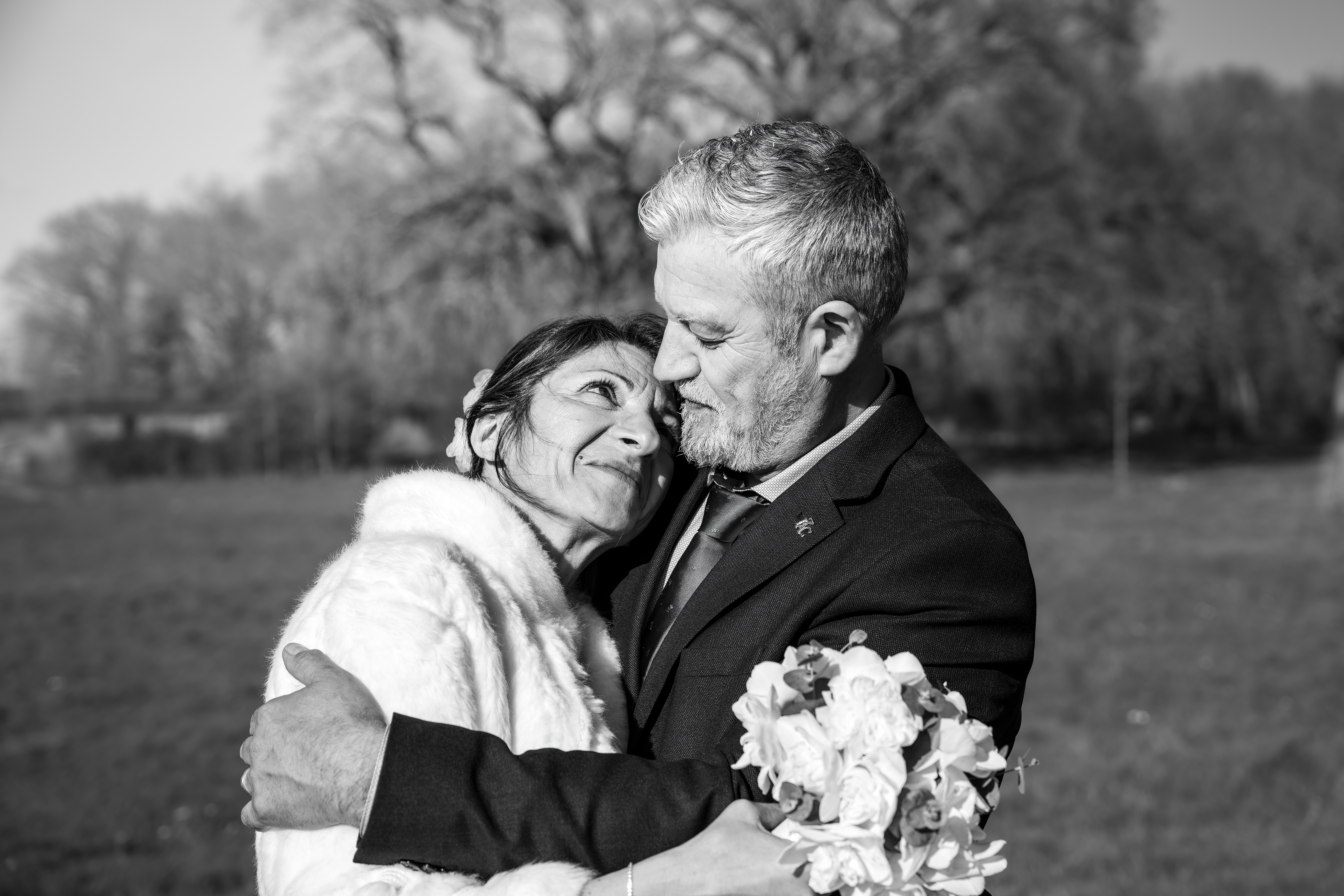 Les mariés s’enlacent, portrait intimiste en noir et blanc.