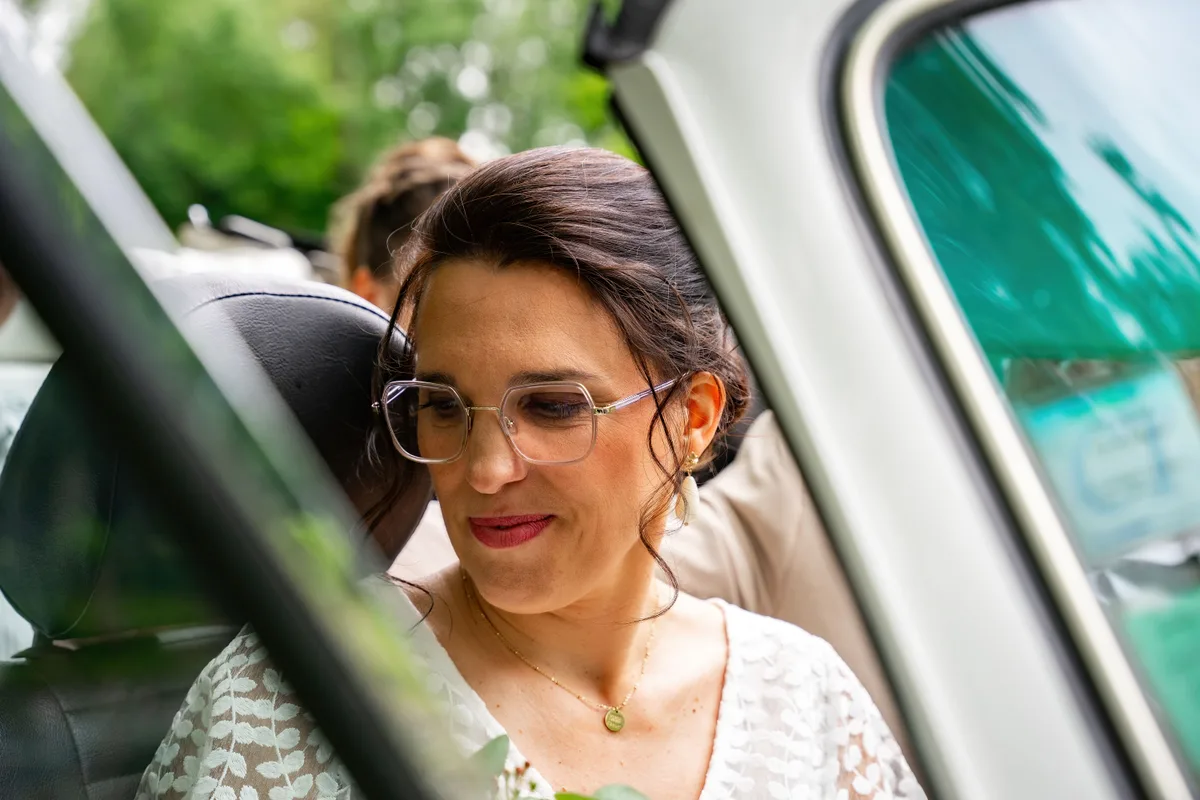 La mariée regarde par la fenêtre de la voiture avant la cérémonie.