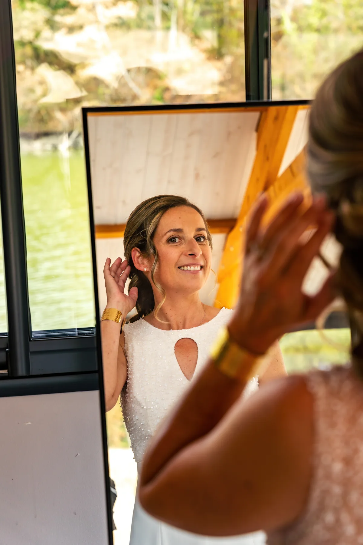 Dernières retouches de maquillage de la mariée devant son miroir.