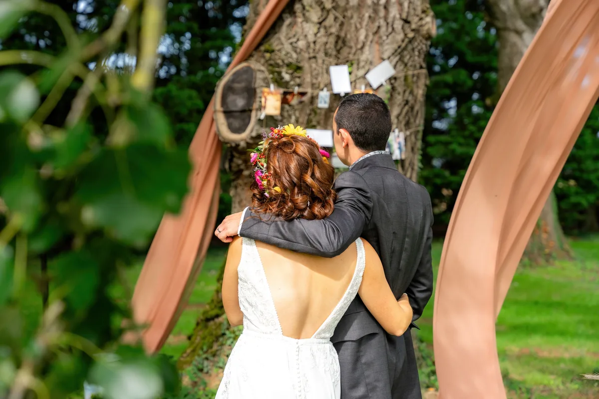 Le marié embrasse la mariée dans le jardin après la cérémonie.
