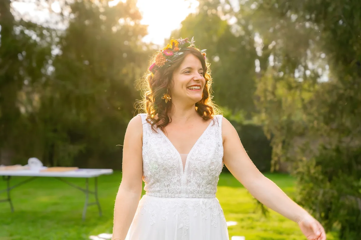 La mariée profite seule du jardin dans la lumière de fin de journée.