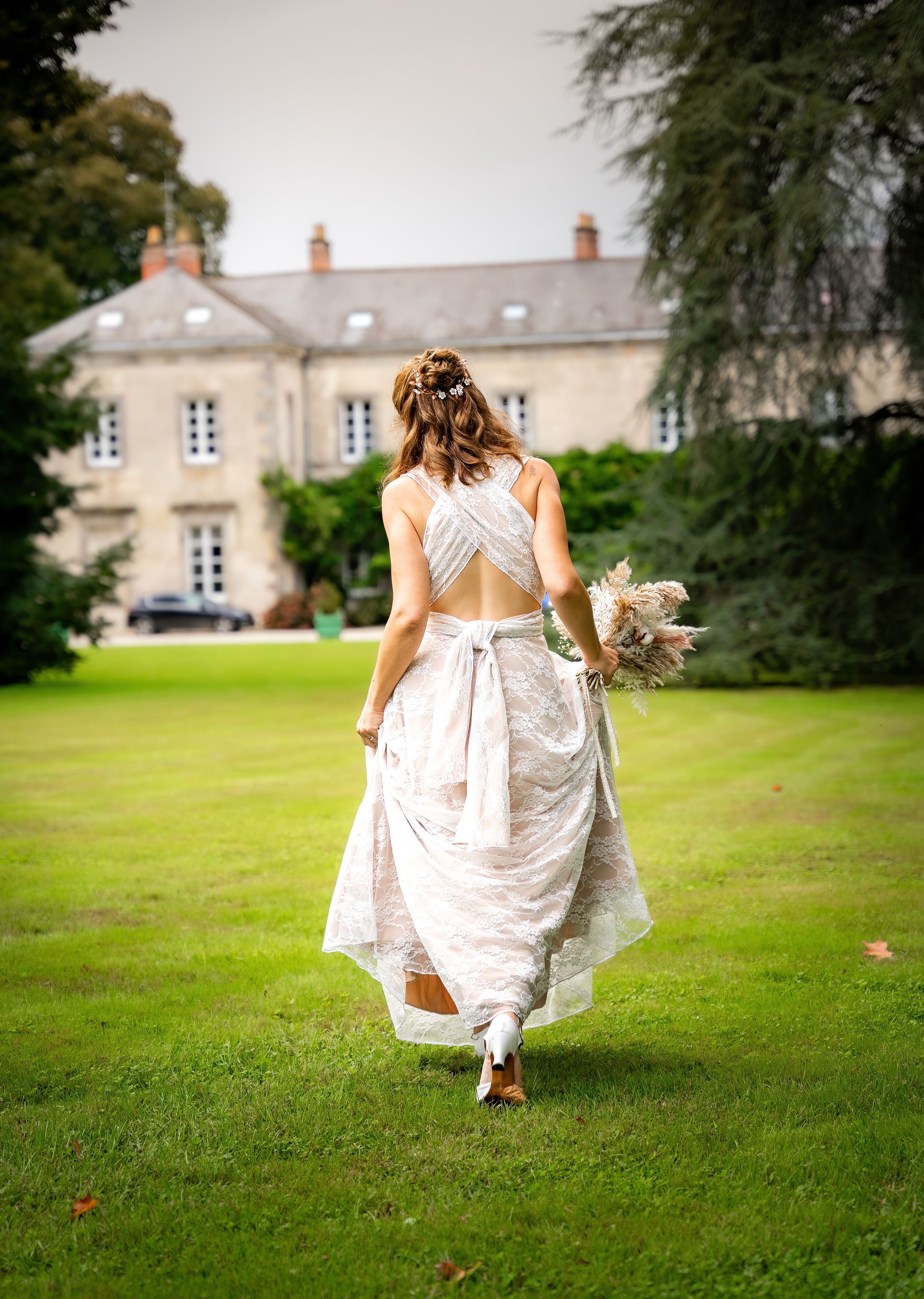 La mariée avance seule dans le parc avant de rejoindre la cérémonie.
