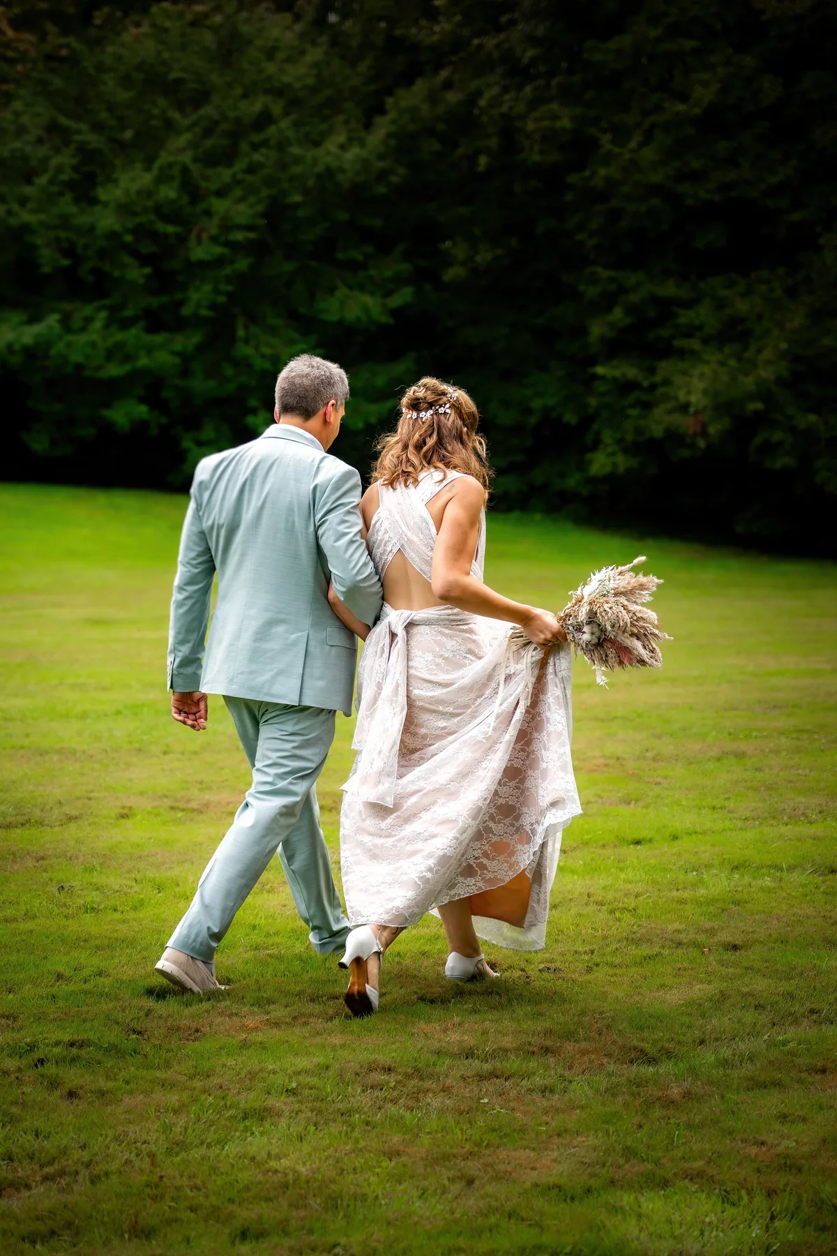 Les mariés courent ensemble dans le parc après la cérémonie.