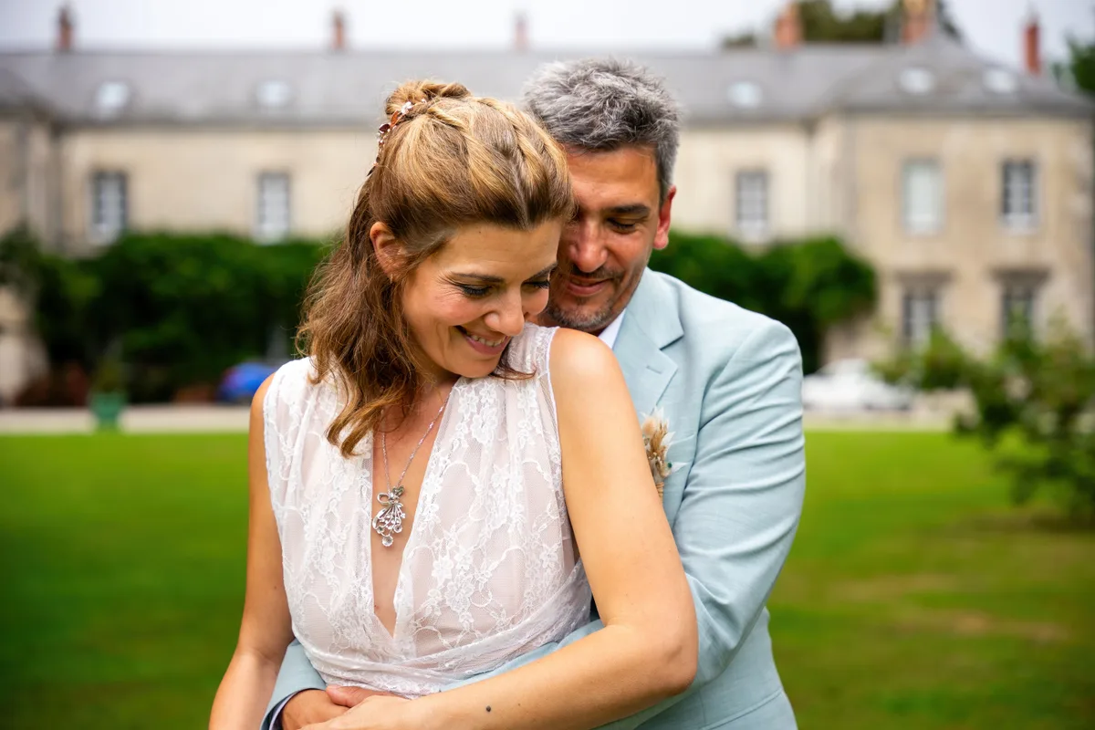 Les mariés échangent un sourire pendant leur séance photo en extérieur.