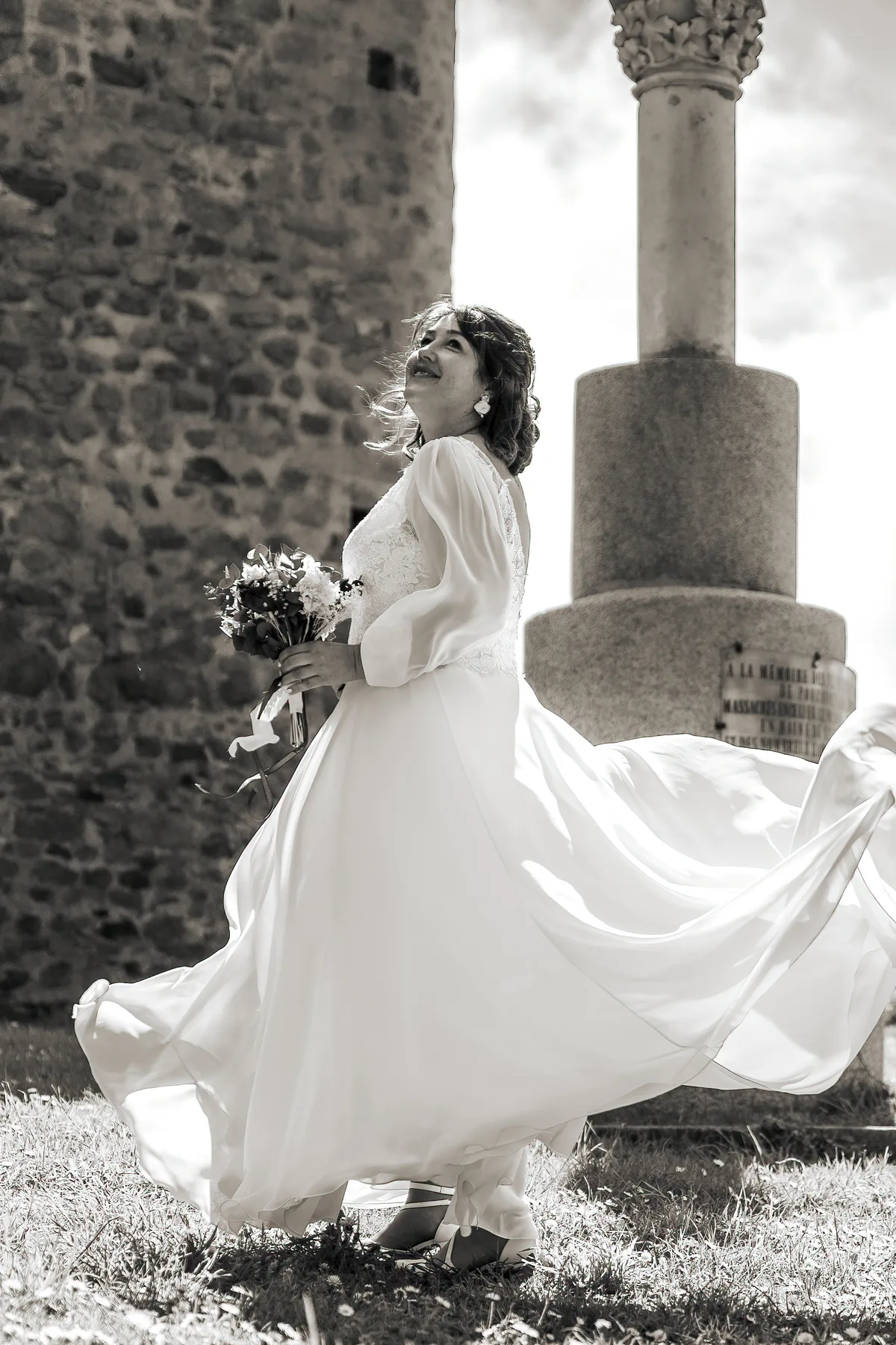 La mariée pose près d’une colonne dans la cour du château.