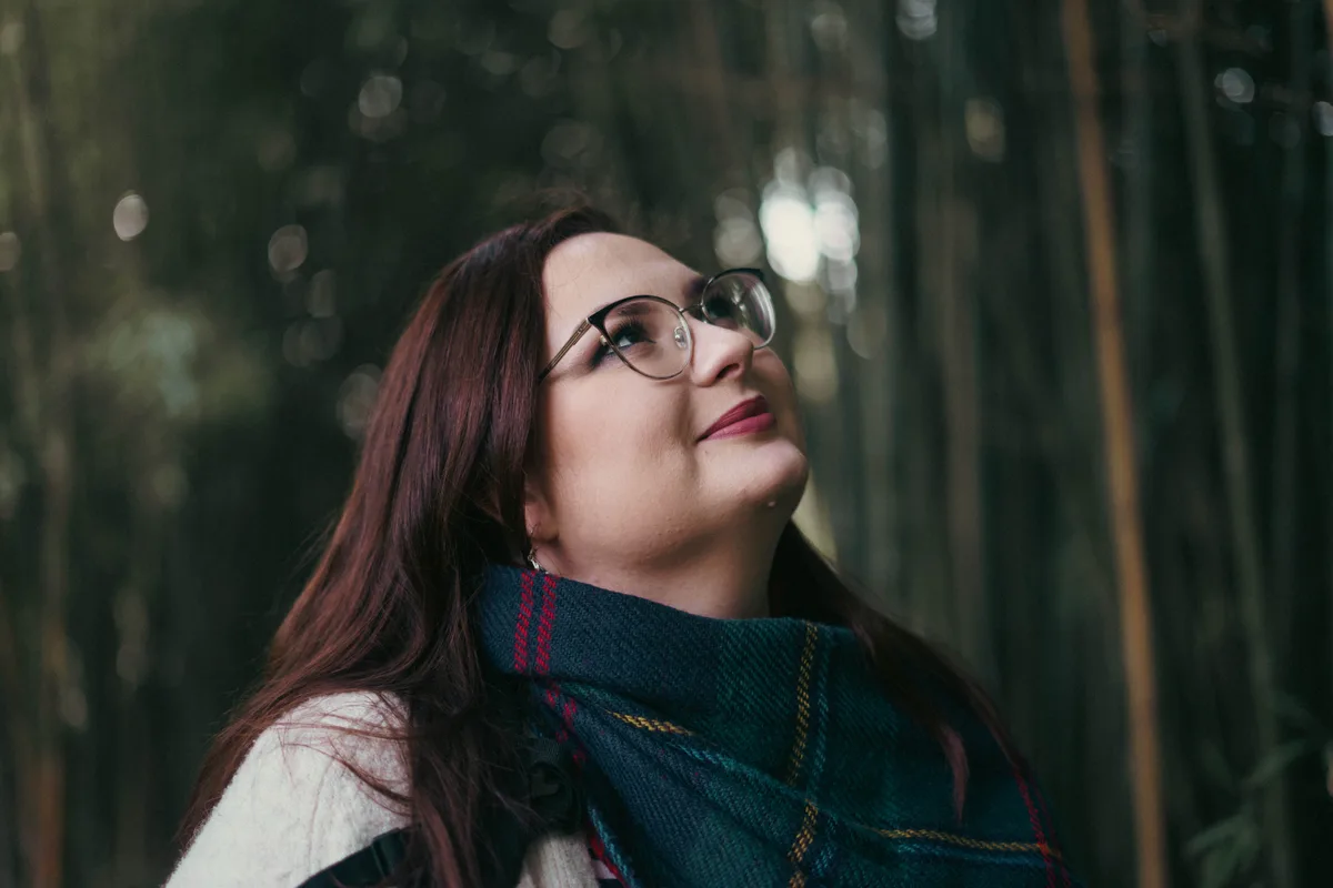 Portrait de Manon en forêt, lunettes et écharpe colorée.