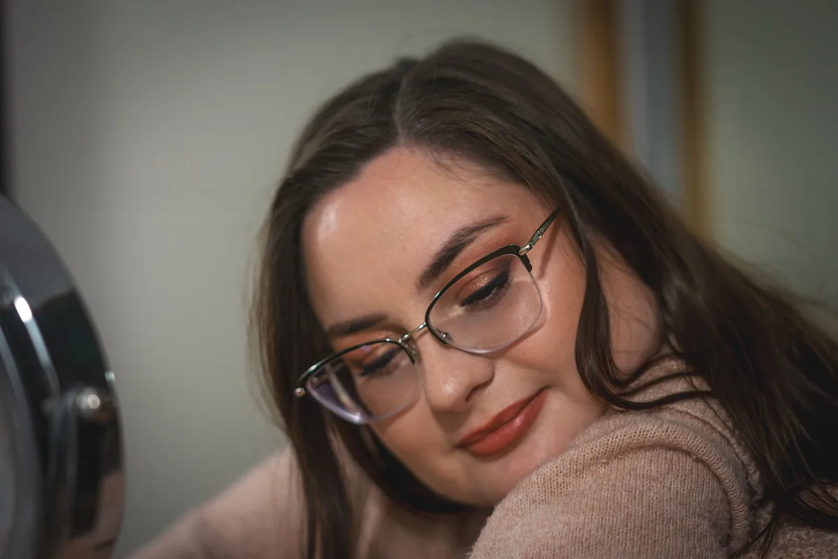 Portrait de Manon avec ses lunettes, le regard tourné vers le bas.