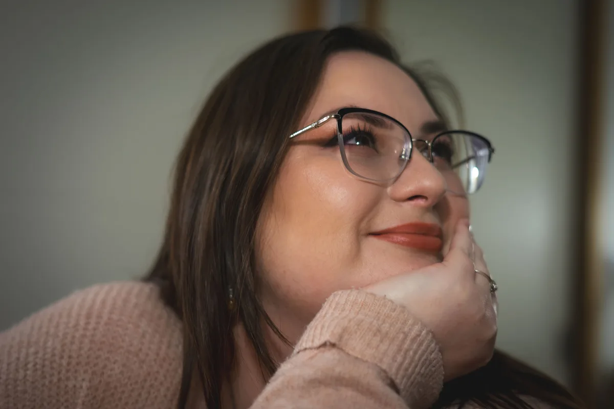 Portrait rapproché de Manon souriante avec ses lunettes.