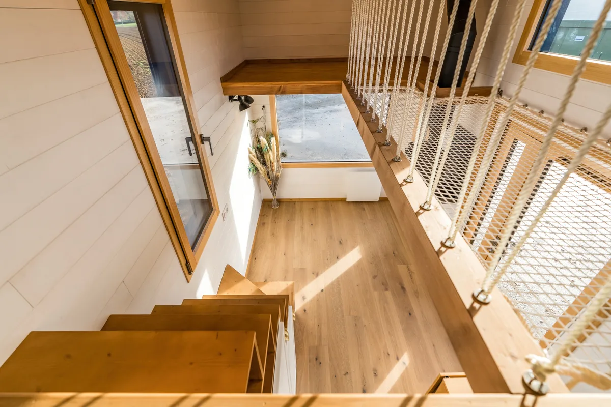 Escalier intérieur et filet suspendu dans une tiny house contemporaine.