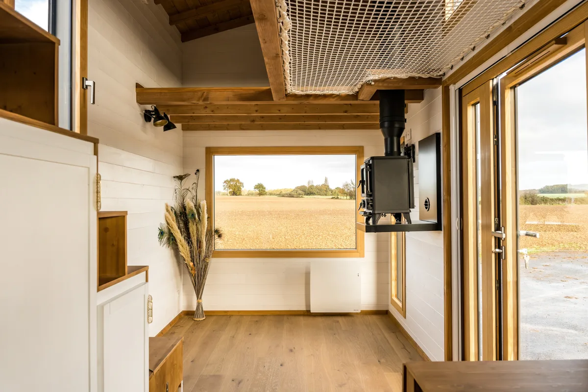 Espace de vie lumineux avec cuisine et grande fenêtre dans la tiny house.